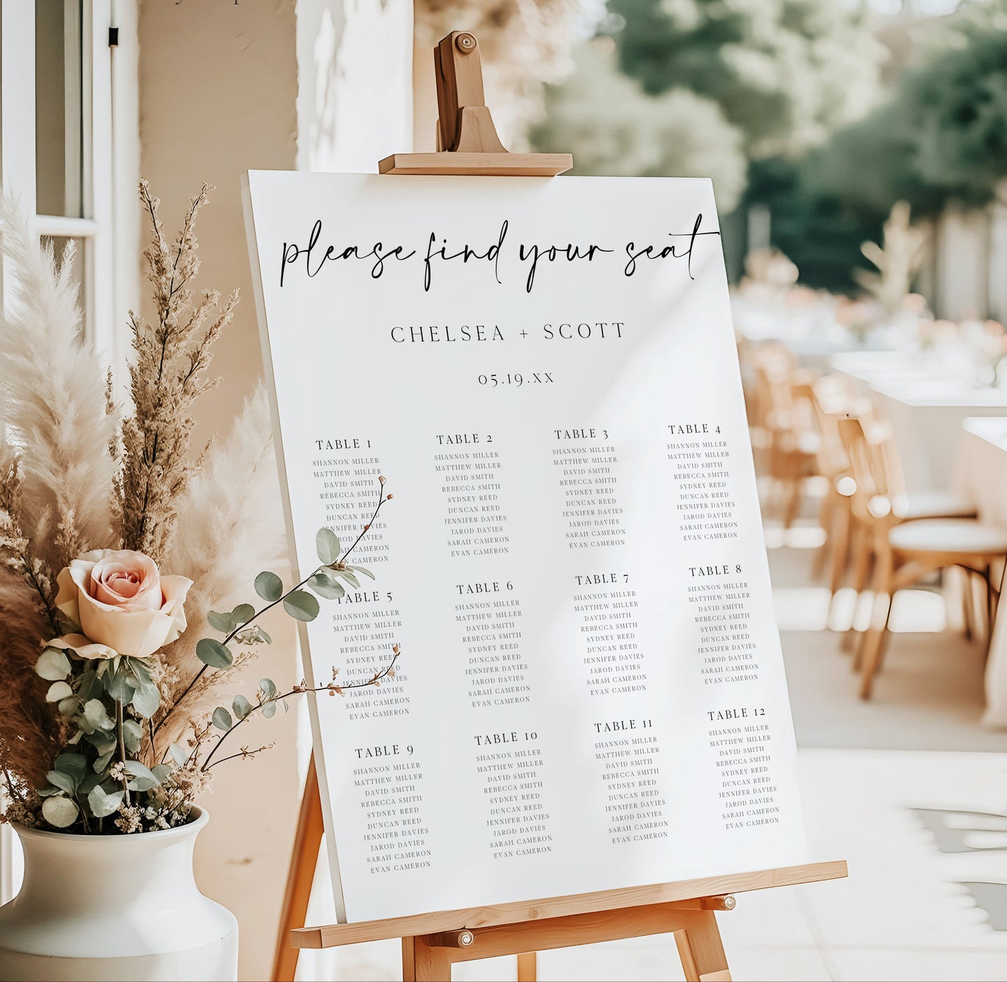 Modern black and white wedding seating chart sign template with oversized calligraphy script and 12 table layout, editable in Canva