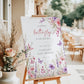 Editable butterfly baby shower welcome sign Canva template with watercolour pink and purple butterflies, peonies, lavender, and wildflower meadow on a white background, shown as a hanging print mockup