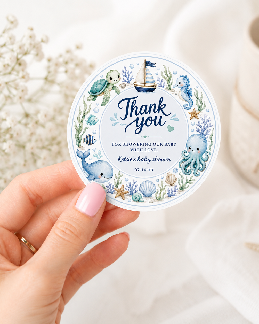 Editable under the sea baby shower round thank you sticker Canva template with watercolour sea turtle, whale, octopus, seahorse, sailboat, coral, shells, and starfish wreath in soft blue tones on a white background