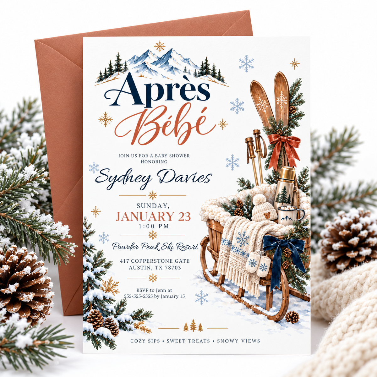 Après Bébé baby shower invitation with wooden skis, a rustic sled, knit baby hat and mittens, hot cocoa, snowy mountains, and evergreen branches