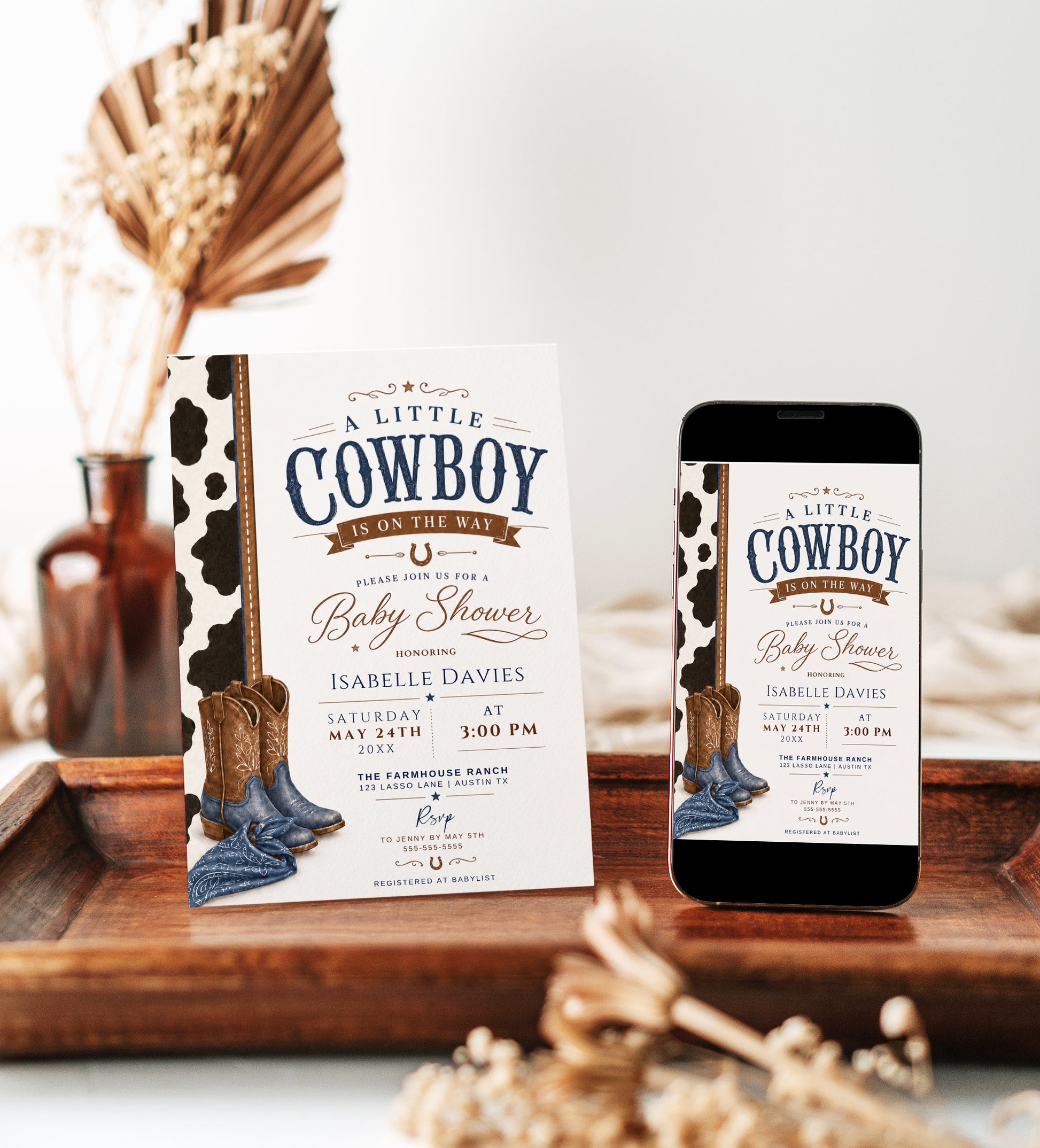 Editable cowboy baby shower invitation Canva template with cowhide side panel, leather cowboy boots, baby denim boots, bandana, horseshoe accent, and bold navy and brown distressed typography on a cream background