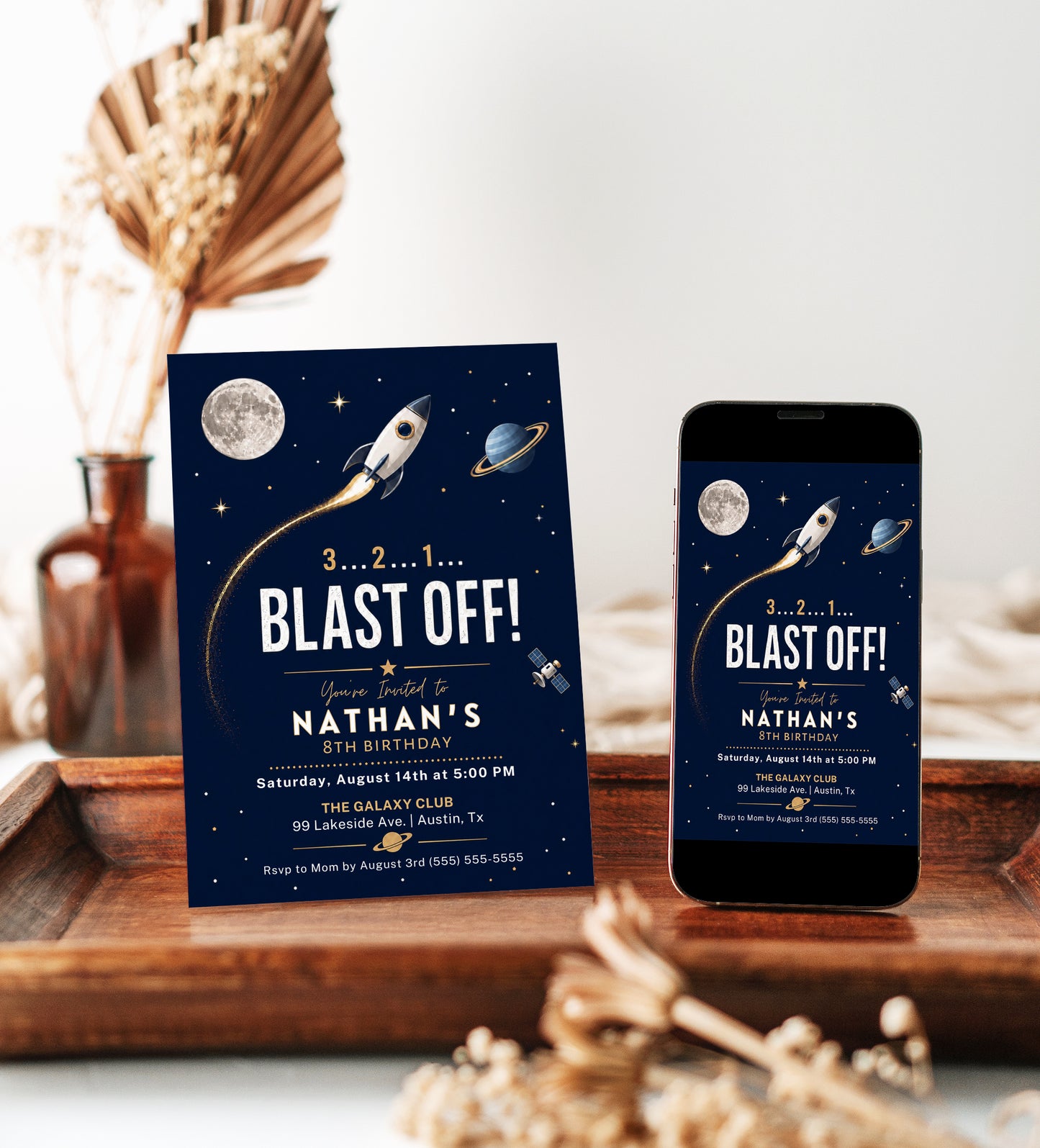 Rocket ship birthday party invitation with a rocket, moon, and planet on a navy and gold space background