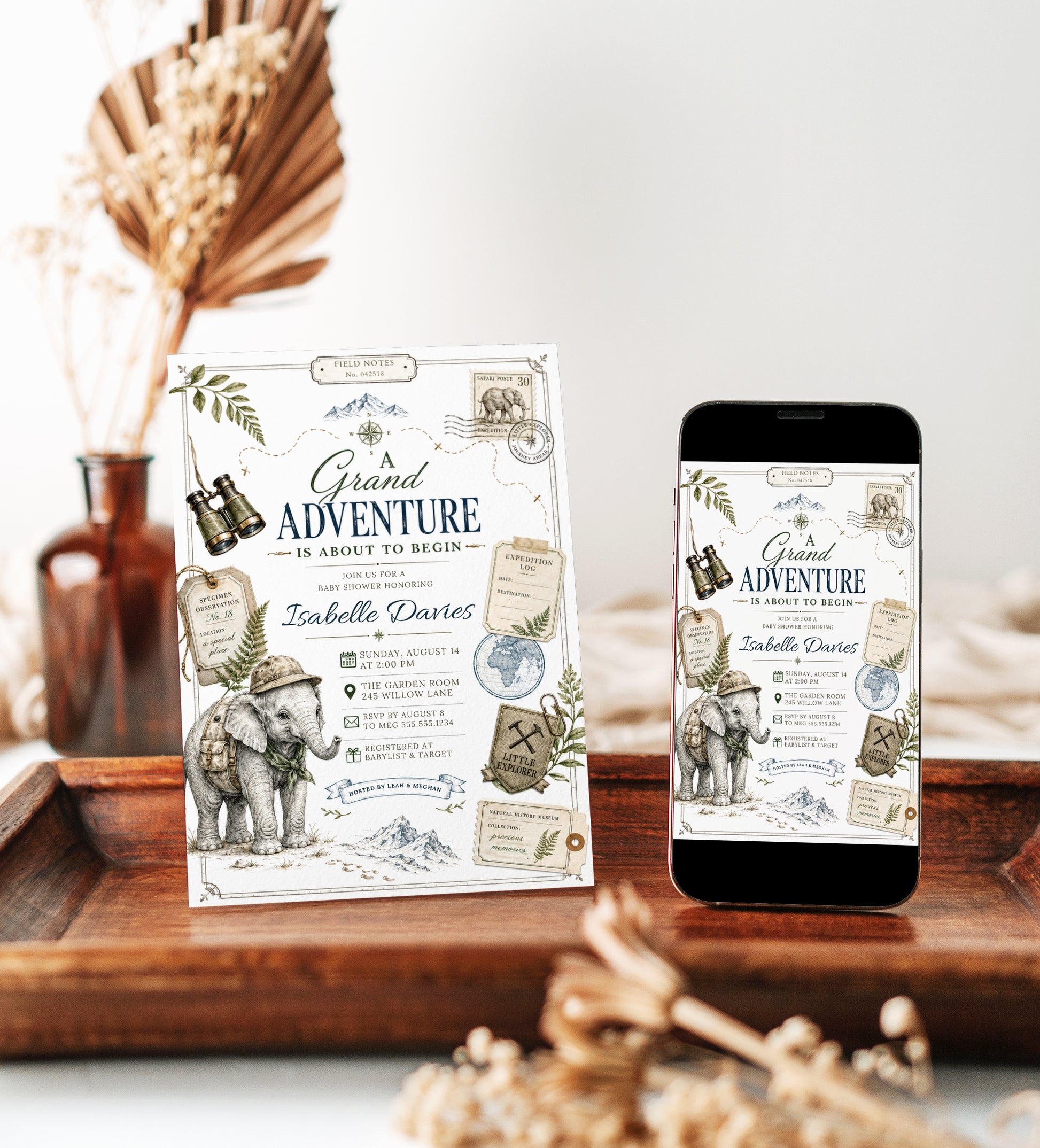 Grand adventure baby shower invitation with safari elephant, binoculars, compass, expedition tags, postage stamp, globe, mountains, greenery, and vintage explorer details