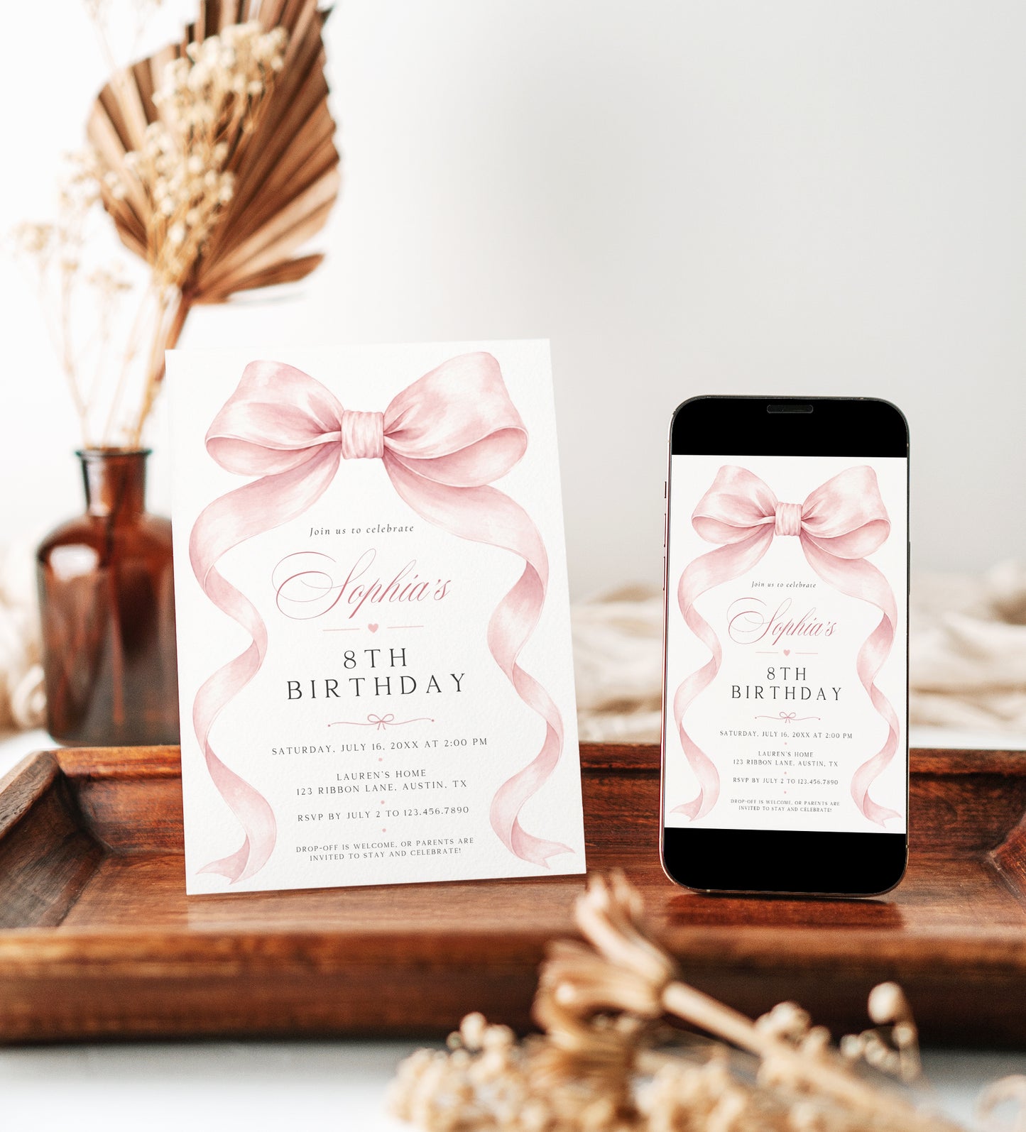 Pink bow birthday invitation for girls featuring a large blush pink ribbon, flowing bow tails and elegant pink and black typography.
