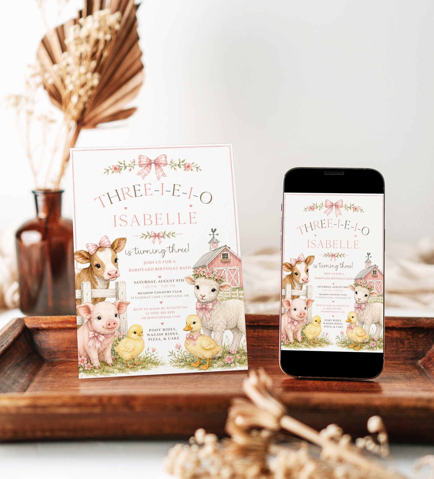Three-I-E-I-O third birthday invitation for girls featuring a pink barn, cow, pig, lamb, chicks, flowers and pink gingham bows.