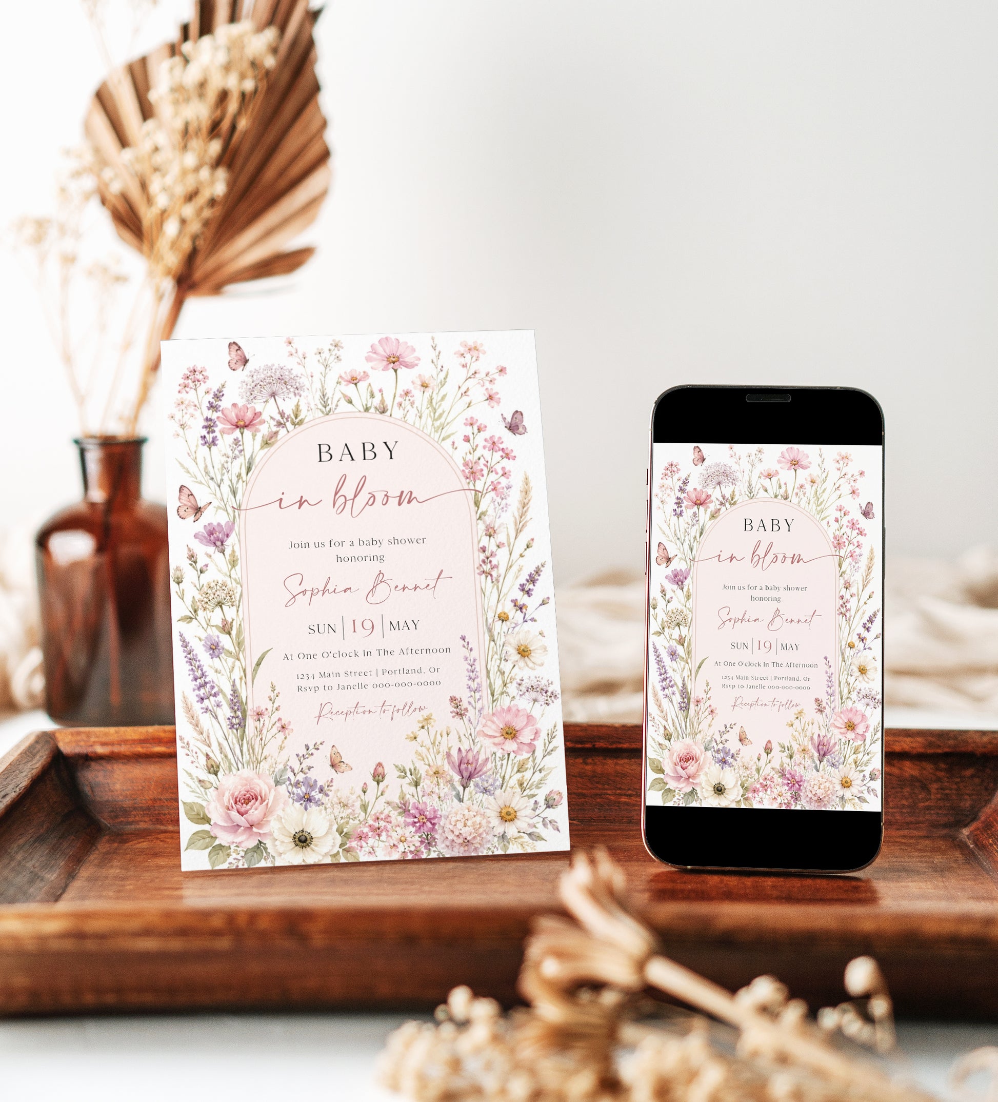 Editable baby in bloom wildflower baby shower invitation Canva template with watercolour roses, cosmos, lavender, and butterfly details framing a blush arch, shown with front and back of card