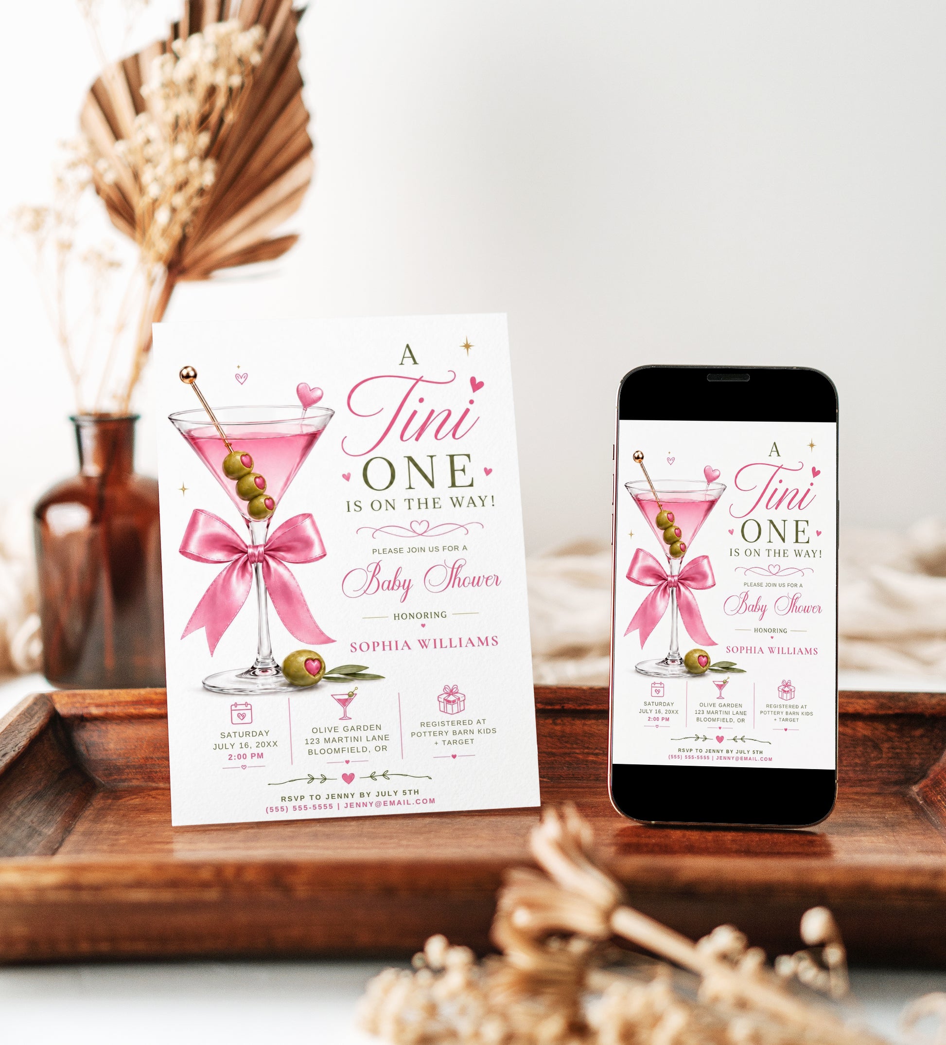 Editable martini baby shower invitation Canva template with pink martini glass, satin bow, heart-topped olive garnish, sparkle accents, and playful pink and olive green typography on a white background