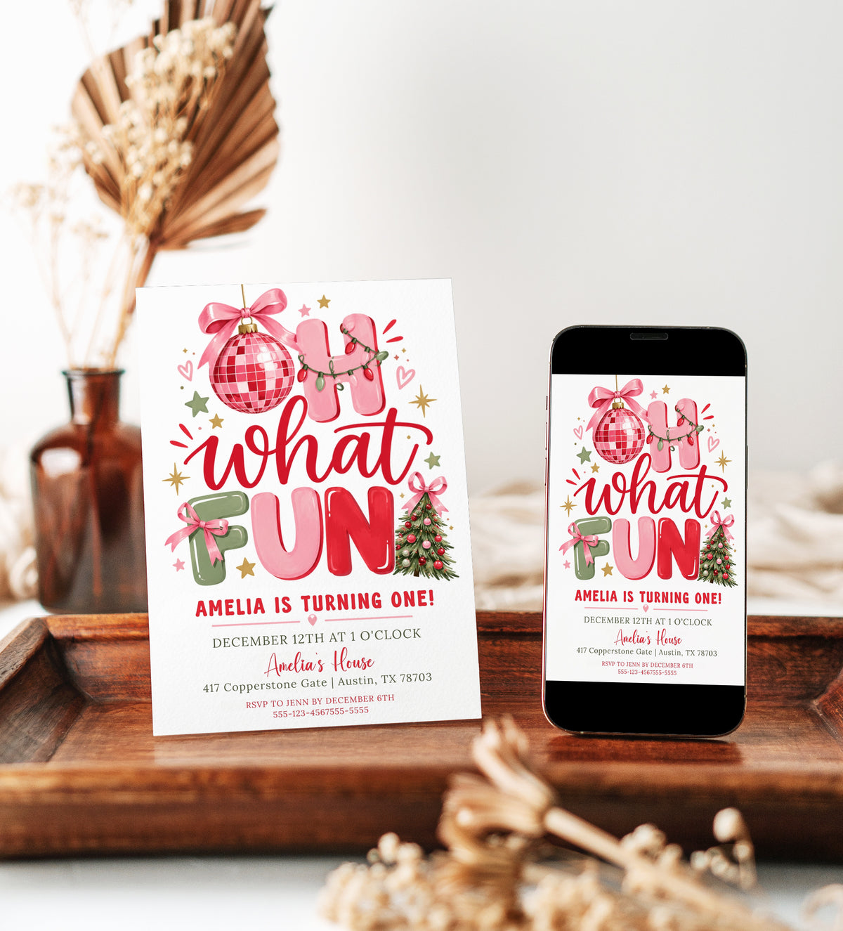Christmas 1st birthday invitation with pink, red, and sage Oh What Fun lettering, a pink disco ornament, ribbon bows, Christmas lights, and a decorated tree