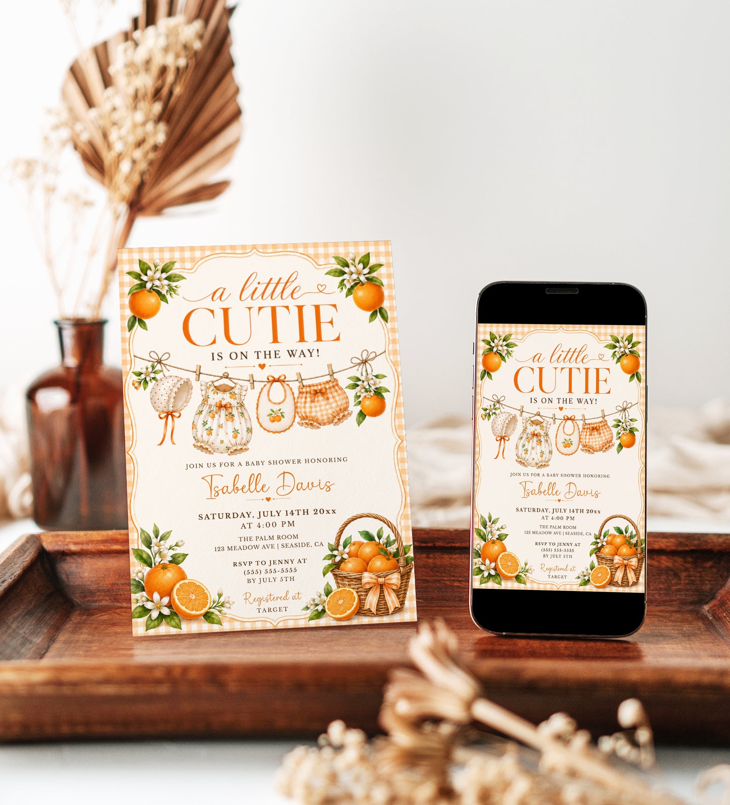 Editable little cutie baby shower invitation Canva template with watercolour oranges, orange blossoms, wicker fruit basket, clothesline scene with romper and bonnet, and orange gingham background