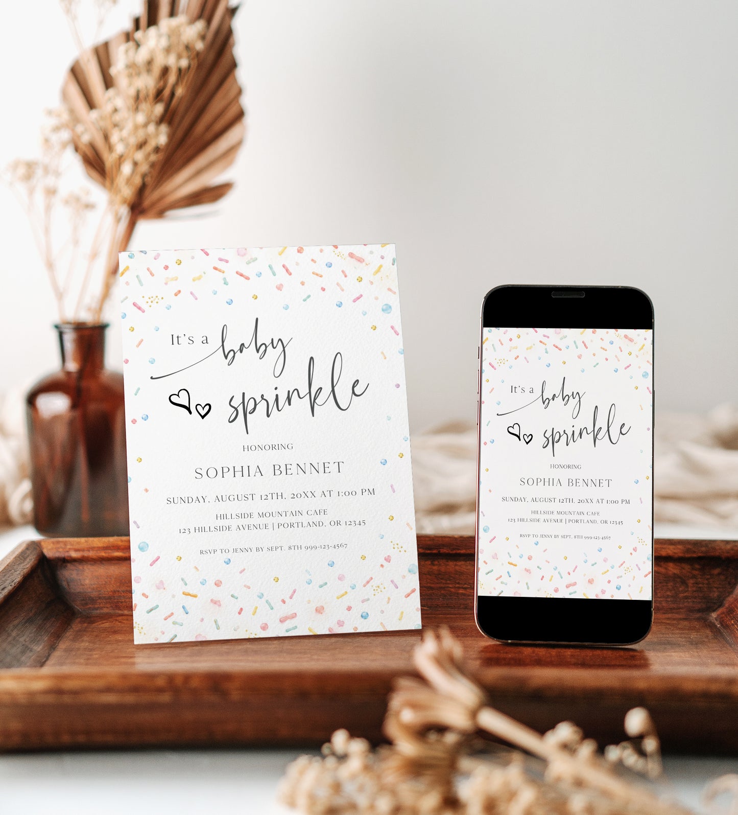 Editable confetti baby sprinkle invitation Canva template with watercolour sprinkles and pearl dots in soft rainbow tones on a white background, with script and serif typography