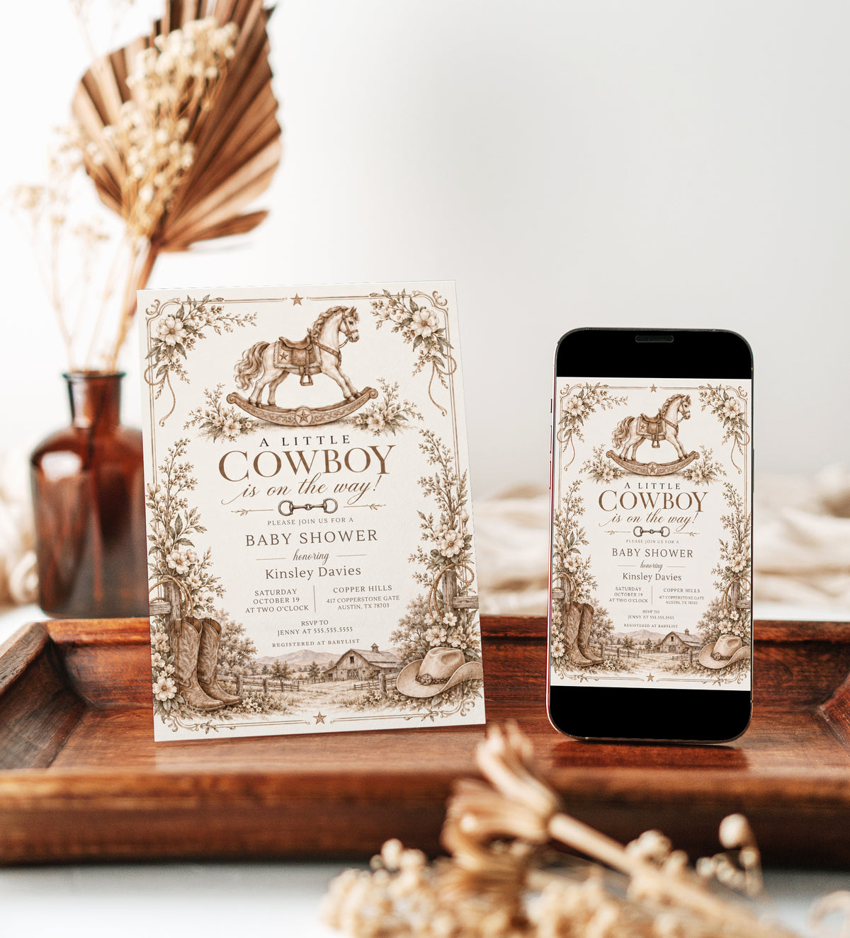 Cowboy baby shower invitation with a brown rocking horse, cowboy boots and hat, rustic barn, and neutral floral border