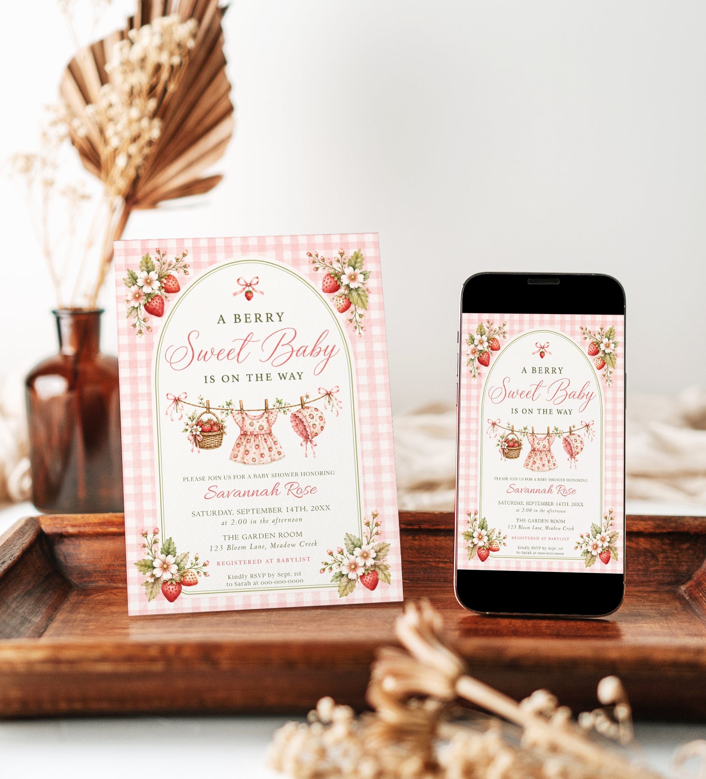 Editable strawberry baby shower invitation Canva template with watercolour strawberries, white blossoms, clothesline scene, and pink gingham background, shown with front and back of card