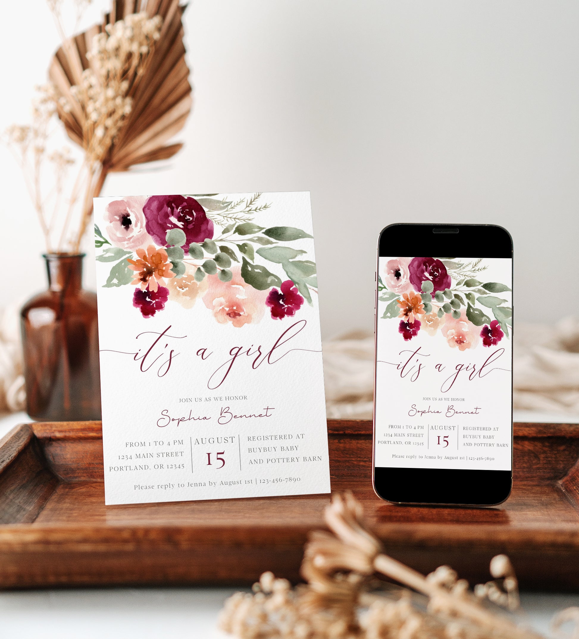 It's a girl burgundy and blush floral baby shower invitation template with watercolor roses in burgundy, peach, and sage green, editable in Canva