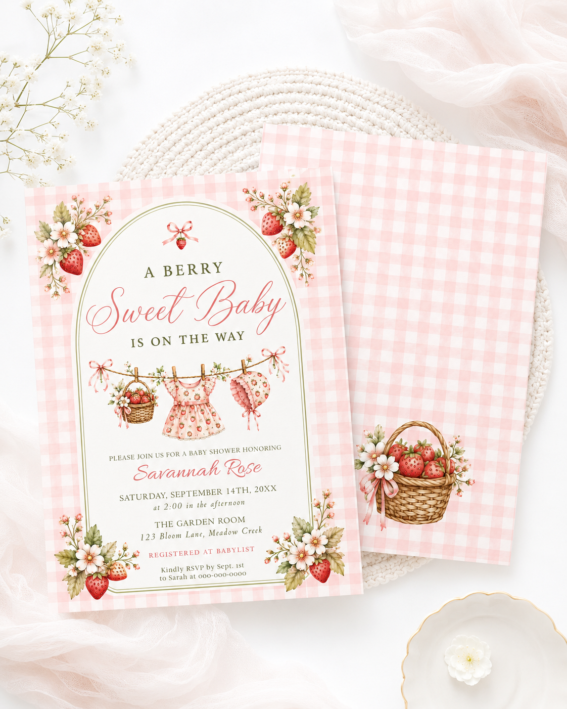 Editable strawberry baby shower invitation Canva template with watercolour strawberries, white blossoms, clothesline scene, and pink gingham background, shown with front and back of card
