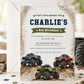 Monster truck birthday invitation featuring blue, red and green trucks racing over muddy hills with tire-track details.
