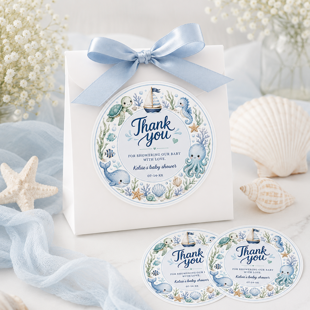 Editable under the sea baby shower round thank you sticker Canva template with watercolour sea turtle, whale, octopus, seahorse, sailboat, coral, shells, and starfish wreath in soft blue tones on a white background