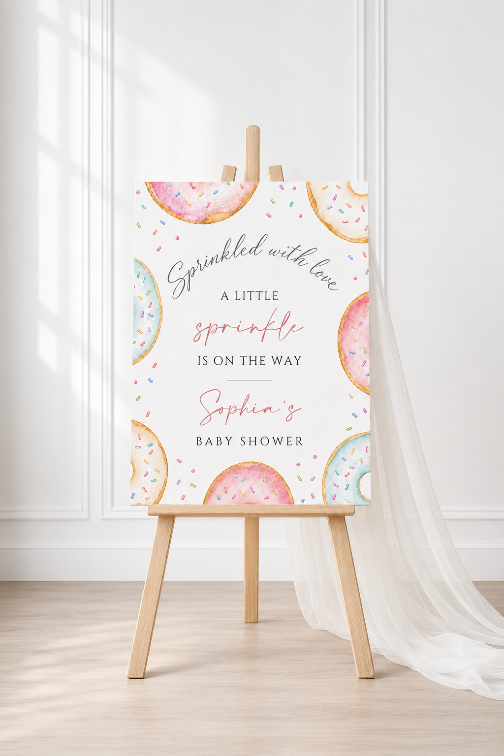 Editable donuts and sprinkles baby shower welcome sign Canva template with watercolour pastel donuts, rainbow sprinkles, and script typography on a soft white background