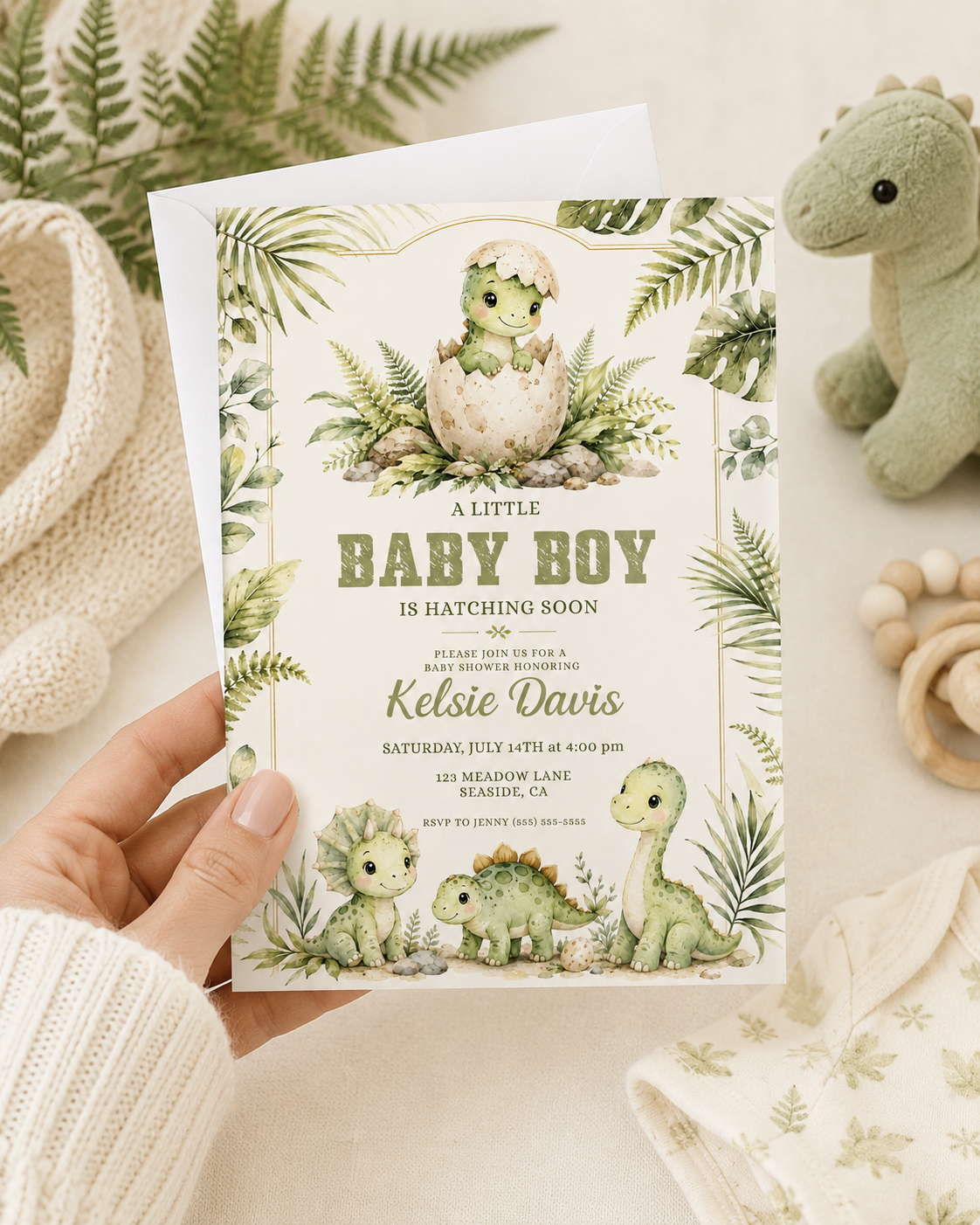 Baby boy dinosaur baby shower invitation with watercolor baby dinosaurs, hatching egg, tropical leaves, ferns, greenery, rocks, and soft sage green details