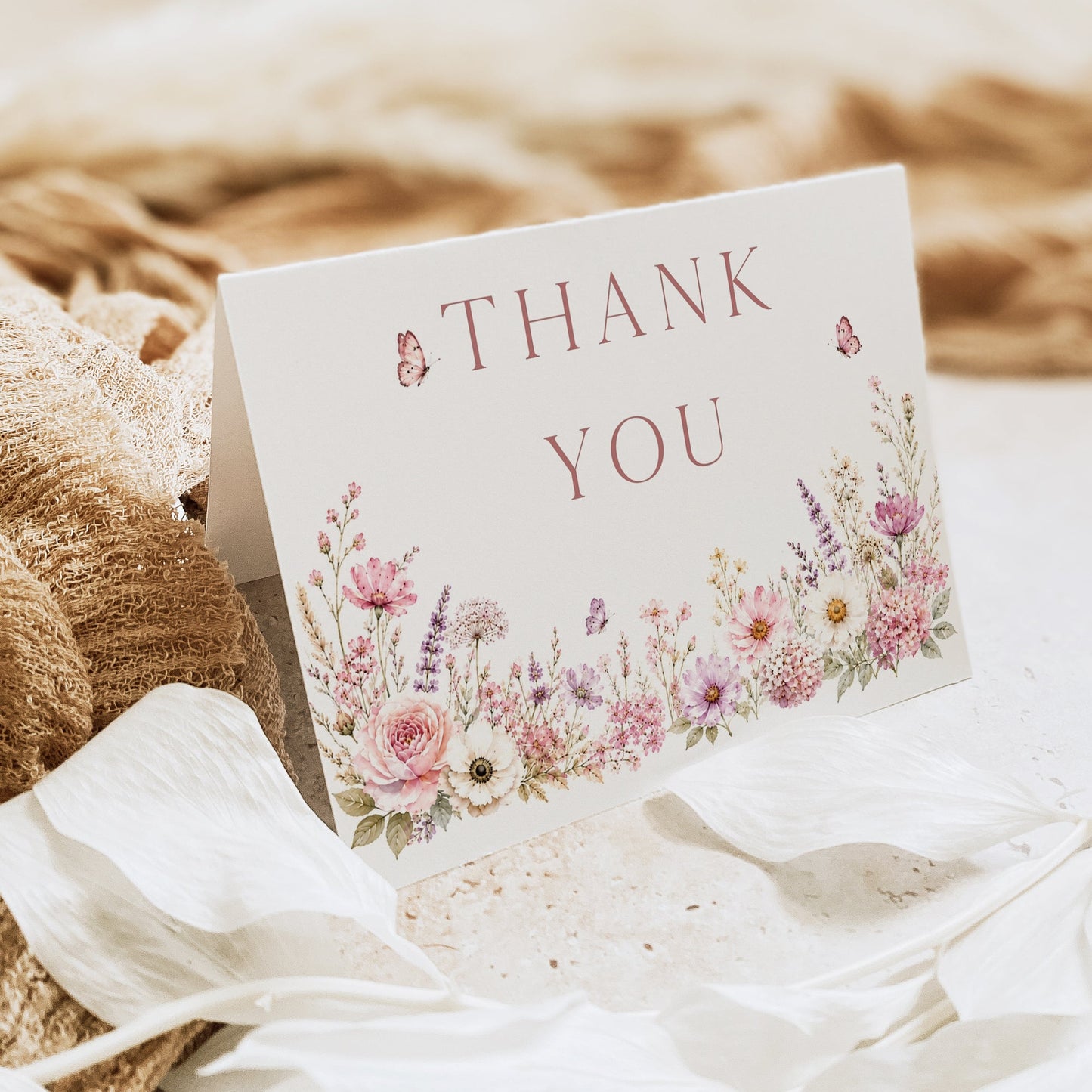 Editable wildflower folded thank you card Canva template with watercolour roses, lavender, daisies, and butterfly details on a white background, shown as a folded card mockup
