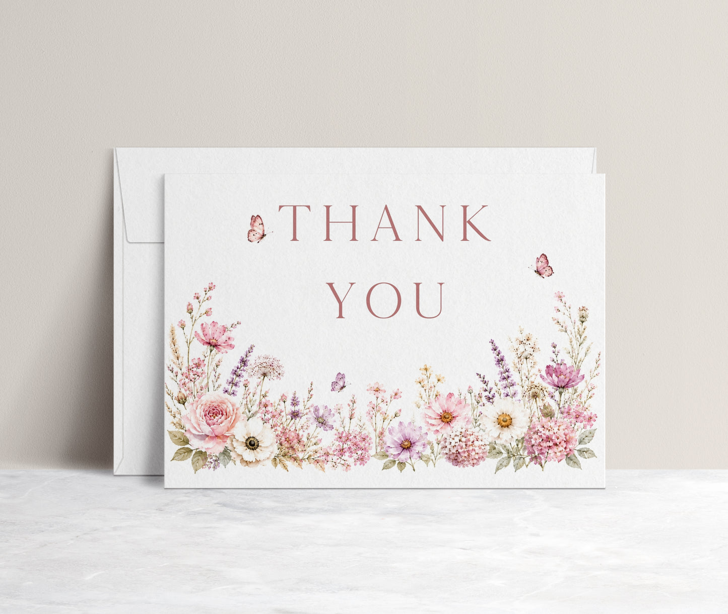 Editable wildflower folded thank you card Canva template with watercolour roses, lavender, daisies, and butterfly details on a white background, shown as a folded card mockup