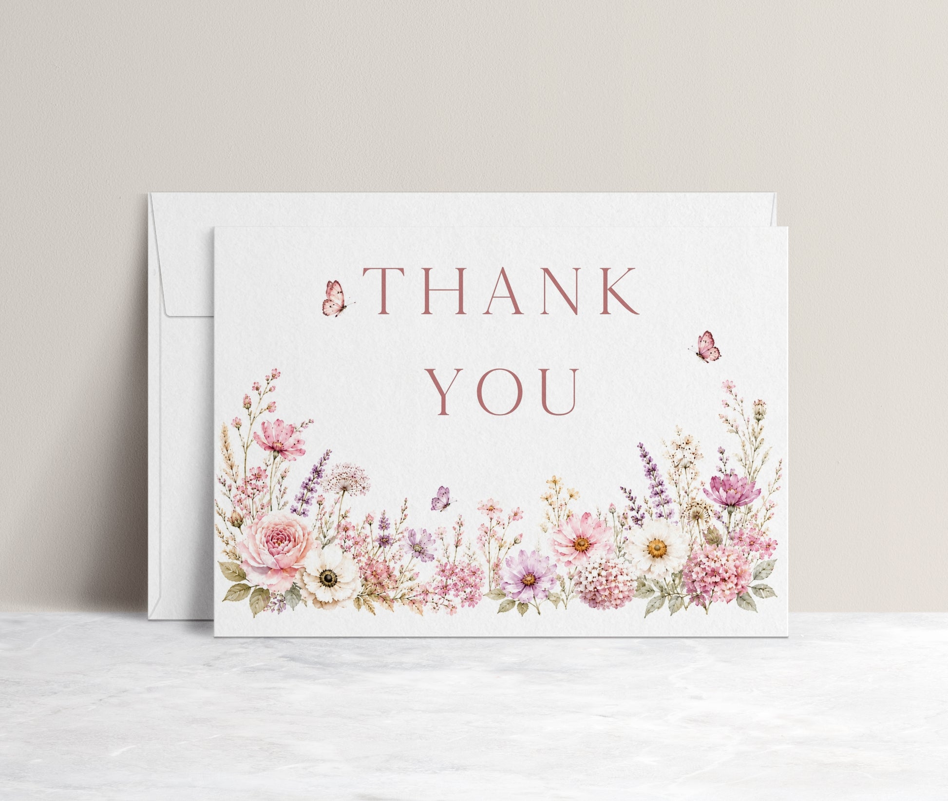 Editable wildflower folded thank you card Canva template with watercolour roses, lavender, daisies, and butterfly details on a white background, shown as a folded card mockup