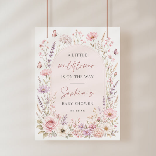 Editable wildflower baby shower welcome sign Canva template with watercolour roses, lavender, cosmos, blush arch, and butterfly details in soft pink and purple tones
