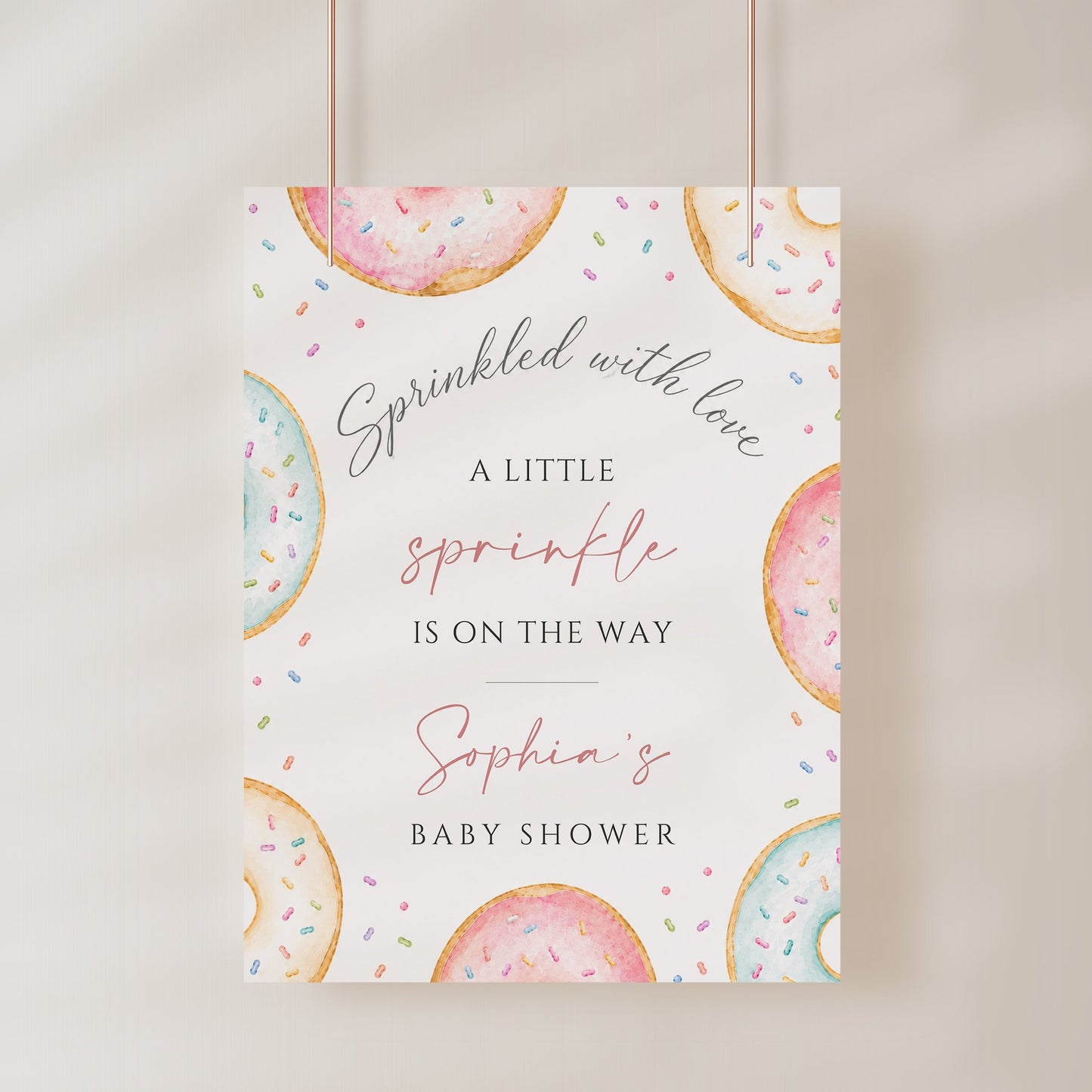 Editable donuts and sprinkles baby shower welcome sign Canva template with watercolour pastel donuts, rainbow sprinkles, and script typography on a soft white background