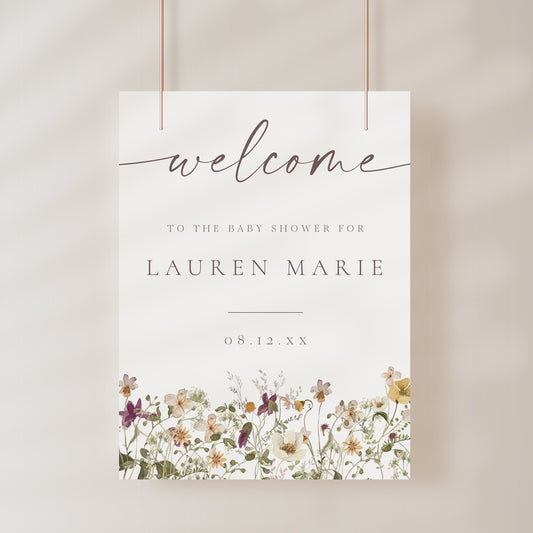 Vertical wildflower baby shower welcome sign template with watercolor meadow flowers in yellow, purple, and cream, editable in Canva