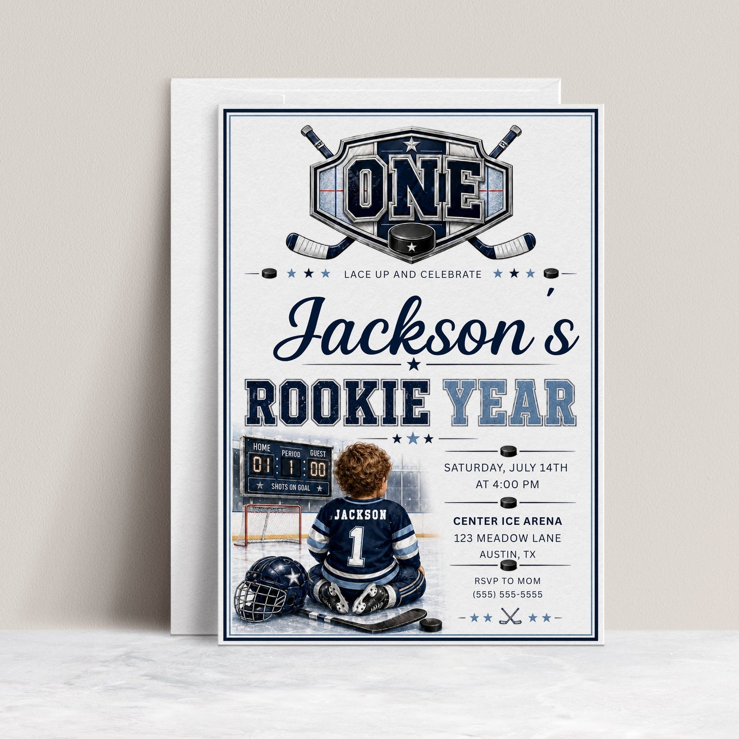 Rookie Year first birthday invitation with little hockey player, ice rink, scoreboard, helmet, hockey sticks, puck, and navy blue birthday party details