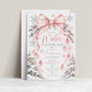 Winter Onederland 1st birthday invitation with a large pink bow, flowing ribbons, silver and pink snowflakes, and snow-covered trees decorated with pink bows