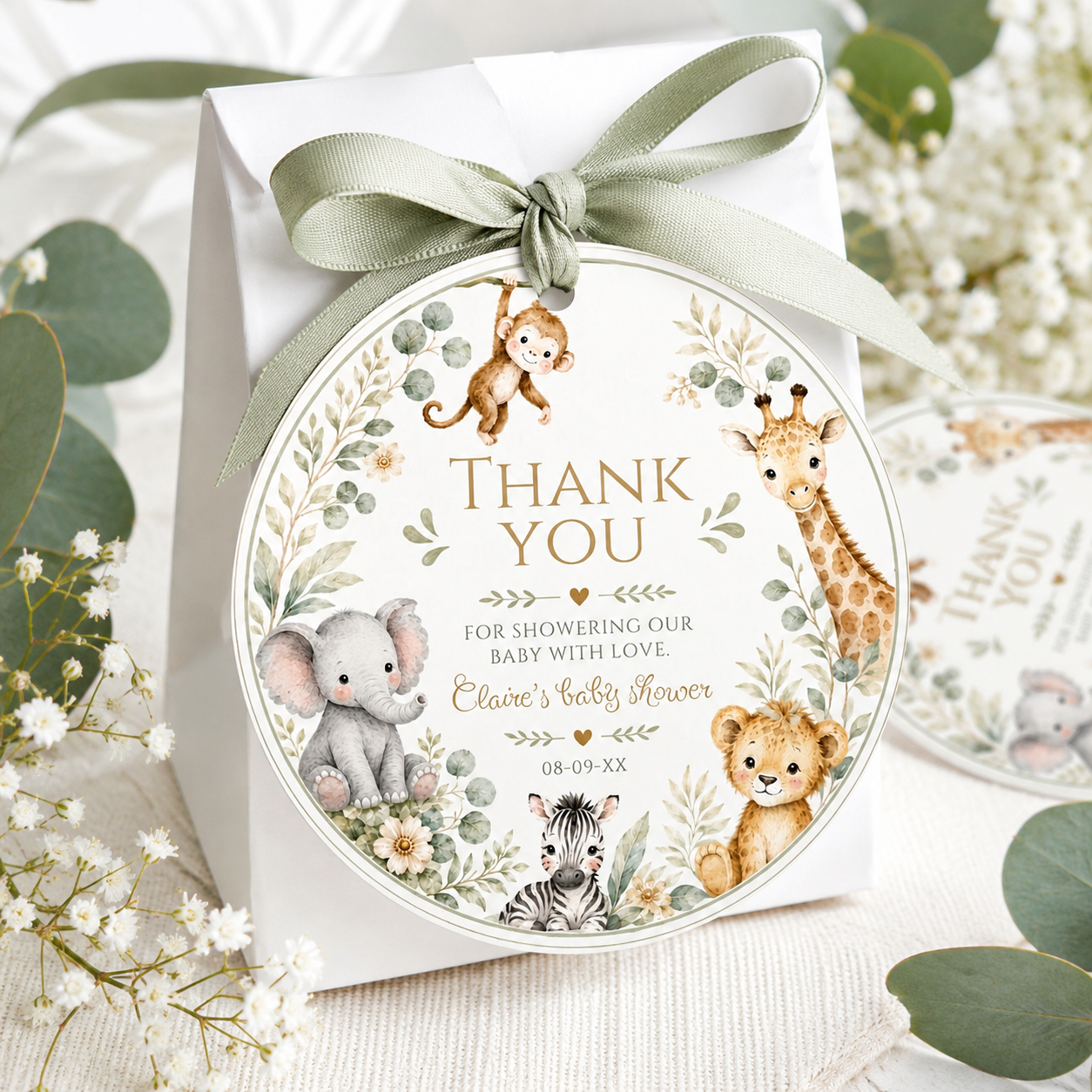 Editable safari baby shower round thank you sticker Canva template with watercolour monkey, giraffe, elephant, lion cub, and zebra in a eucalyptus and tropical leaf wreath on a cream background